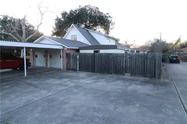 a view of an house with backyard space and wooden fence