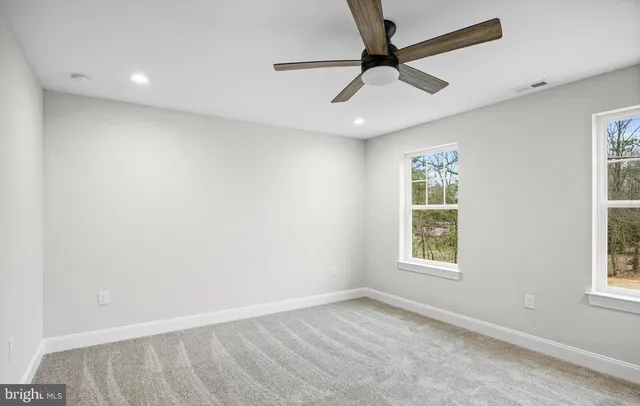 an empty room with a window and a ceiling fan