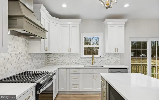 a kitchen with granite countertop a sink stove and cabinets