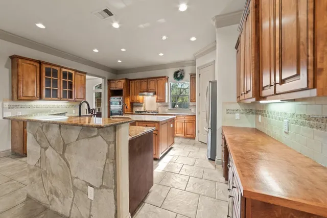 a kitchen with stainless steel appliances granite countertop a sink and a stove