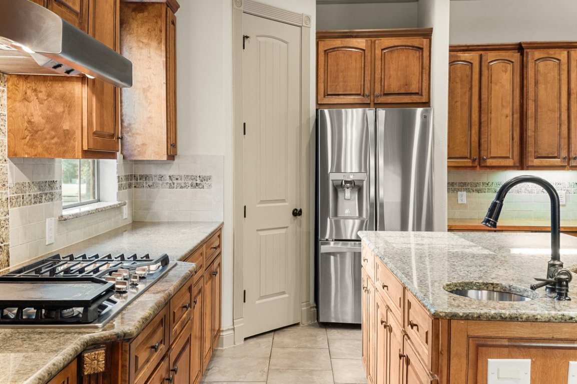 139 Ware Drive Buda, TX 78610 - Photo 12 of 40 a kitchen with granite countertop a refrigerator stove and sink