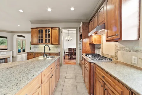 a kitchen with stainless steel appliances granite countertop a sink stove and cabinets