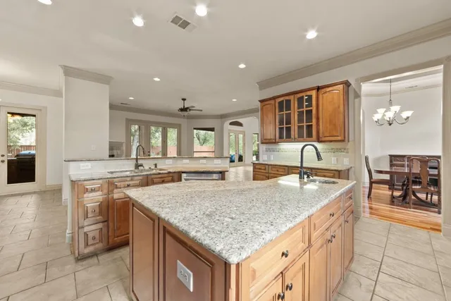 a kitchen with granite countertop a stove and white cabinets
