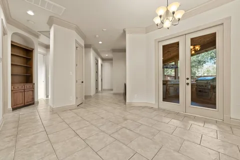 a view of a hallway with wooden floor and a chandelier