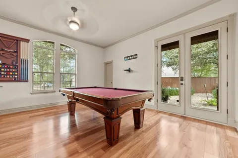 a room with pool table and a wooden floor