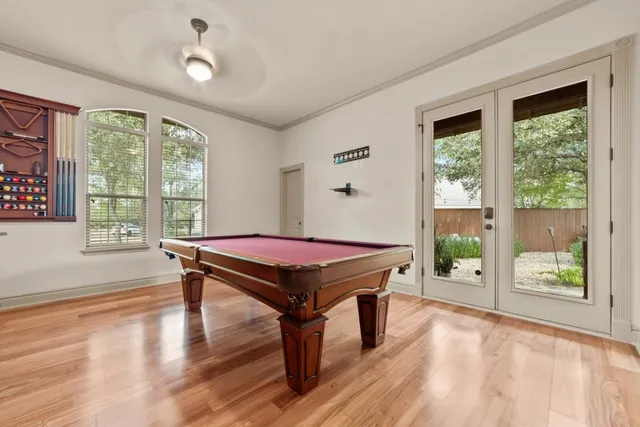 a room with pool table and a wooden floor