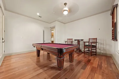 a room with wooden floor and pool table