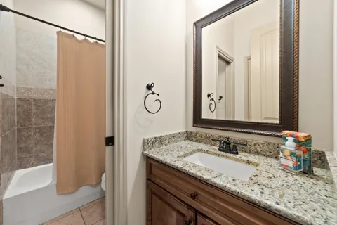 a bathroom with a granite countertop sink and a mirror