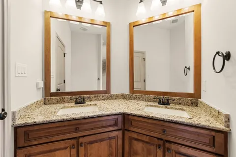 a bathroom with a granite countertop sink and a mirror