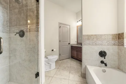 a bathroom with a granite countertop sink a toilet and shower