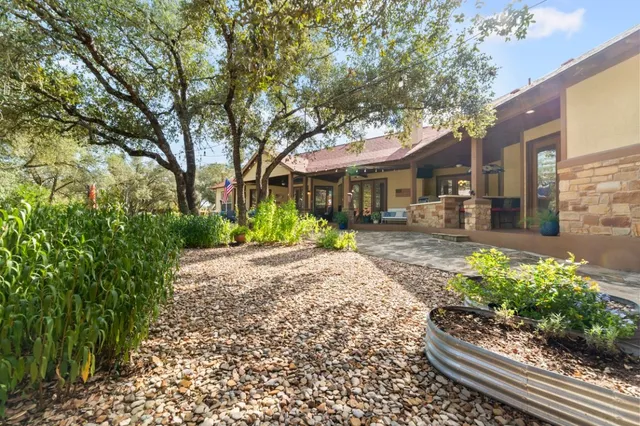 a front view of a house with a yard and potted plants