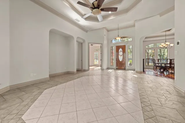 a view of a livingroom with a chandelier fan and windows