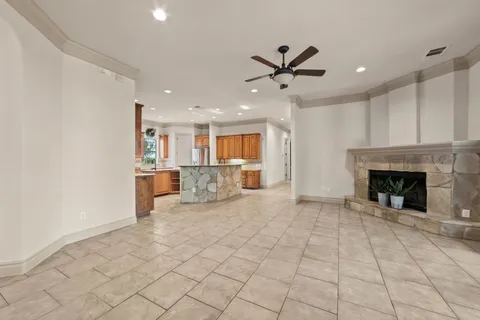 a view of a livingroom with a fireplace a sink and a kitchen space