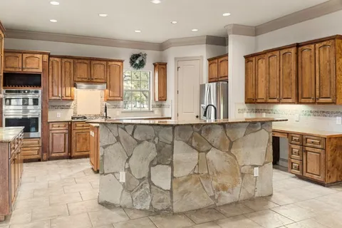 a kitchen with stainless steel appliances granite countertop a stove a sink and a refrigerator