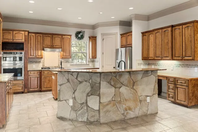 a kitchen with stainless steel appliances granite countertop a stove a sink and a refrigerator