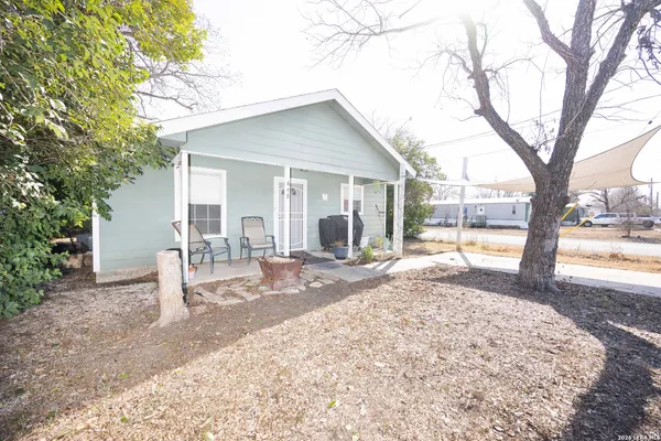 a view of a house with backyard and sitting area
