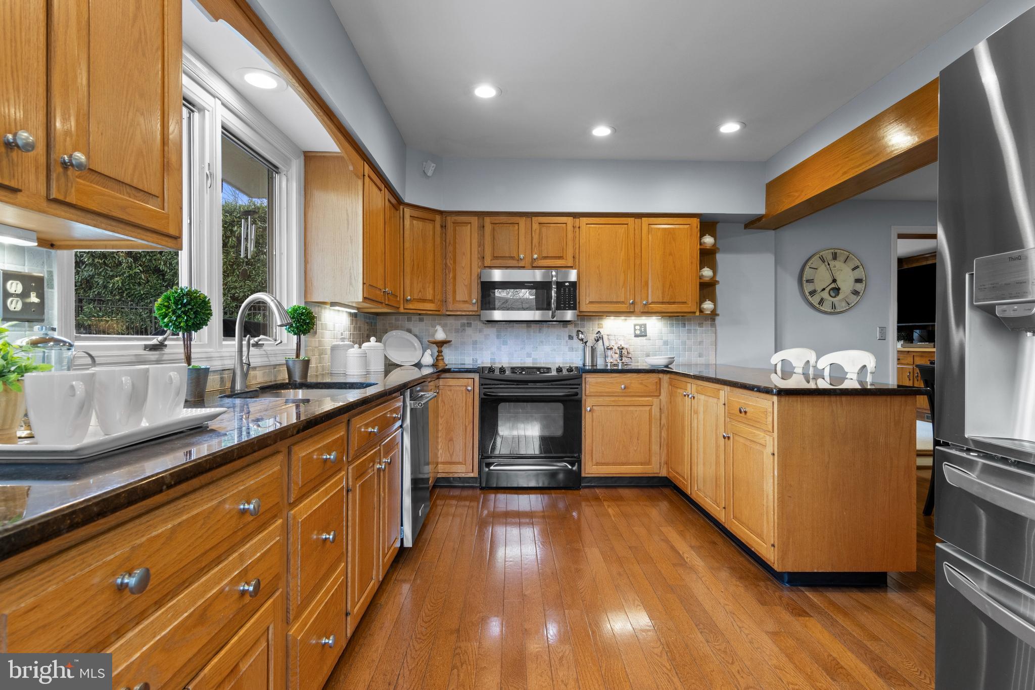 421 St Davids Road Wayne, PA 19087 - Photo 16 of 39 a kitchen with granite countertop wooden floors stainless steel appliances and a counter space