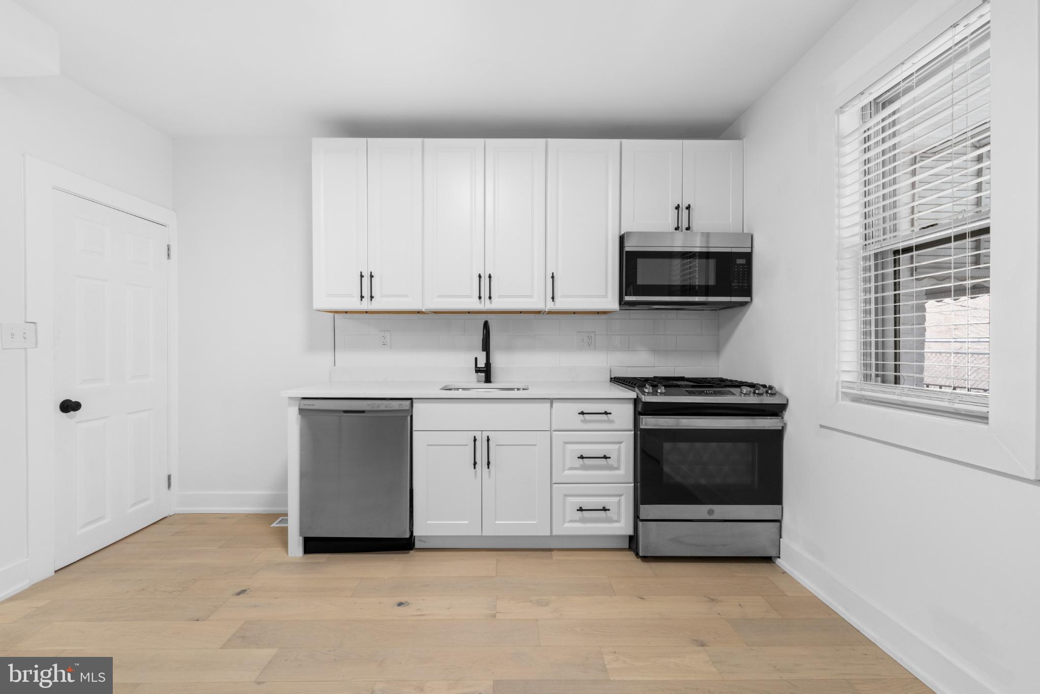 2508 East Indiana Avenue Philadelphia, PA 19134 - Photo 11 of 37 a kitchen with granite countertop a stove and a sink