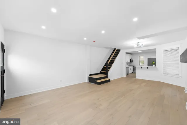 a view of a hallway with wooden floor and staircase