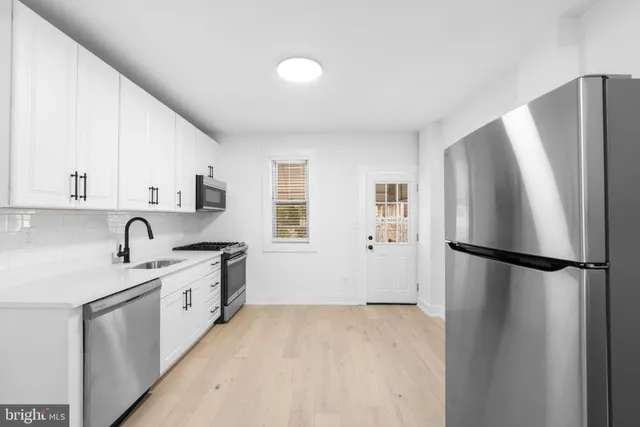 a kitchen with stainless steel appliances a refrigerator sink and cabinets
