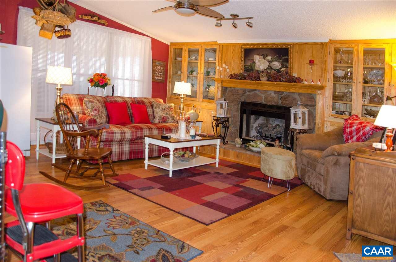 3919 Firehouse Road Howardsville, VA 24562 - Photo 16 of 49 a living room with furniture a rug and a fireplace