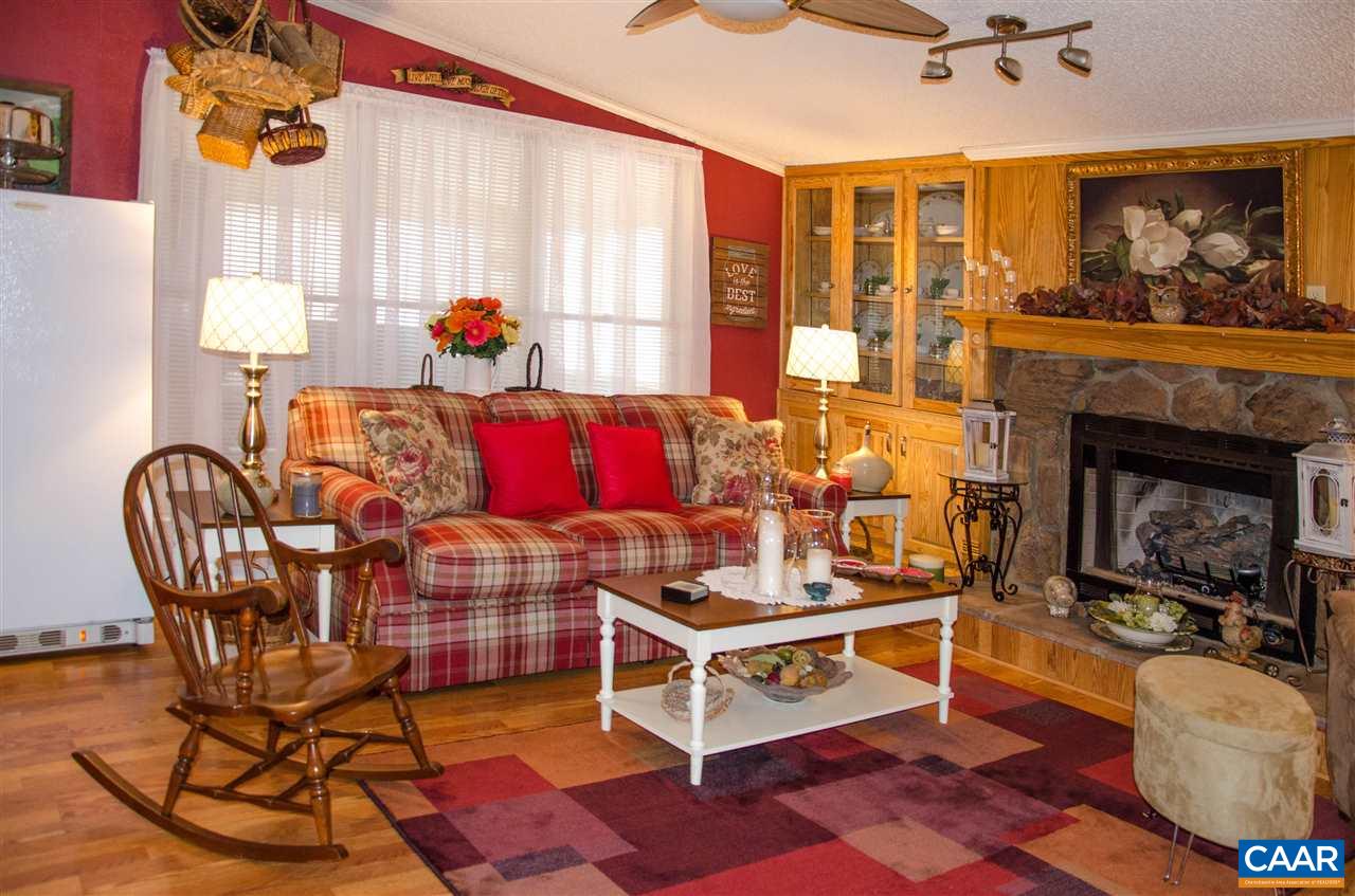 3919 Firehouse Road Howardsville, VA 24562 - Photo 17 of 49 a living room with furniture a fireplace and a chandelier