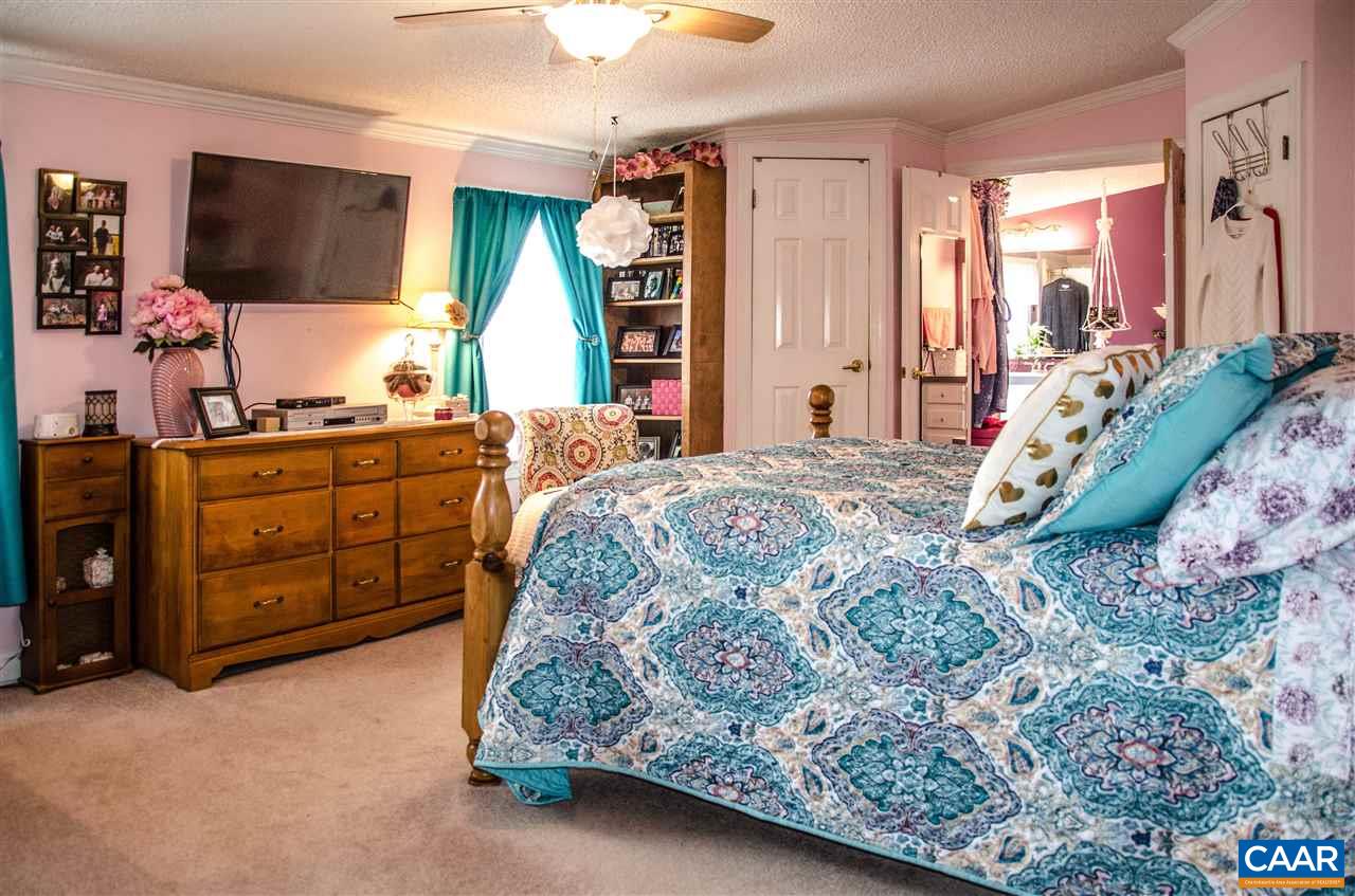 3919 Firehouse Road Howardsville, VA 24562 - Photo 25 of 49 a bedroom with a bed and a flat tv screen on dresser