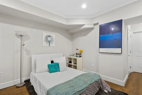 a bedroom with a bed and wooden floor