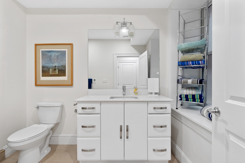 1471 Beacon Street, Unit 1 Brookline, MA 02446 - Photo 17 of 20 a bathroom with a sink a toilet and a mirror