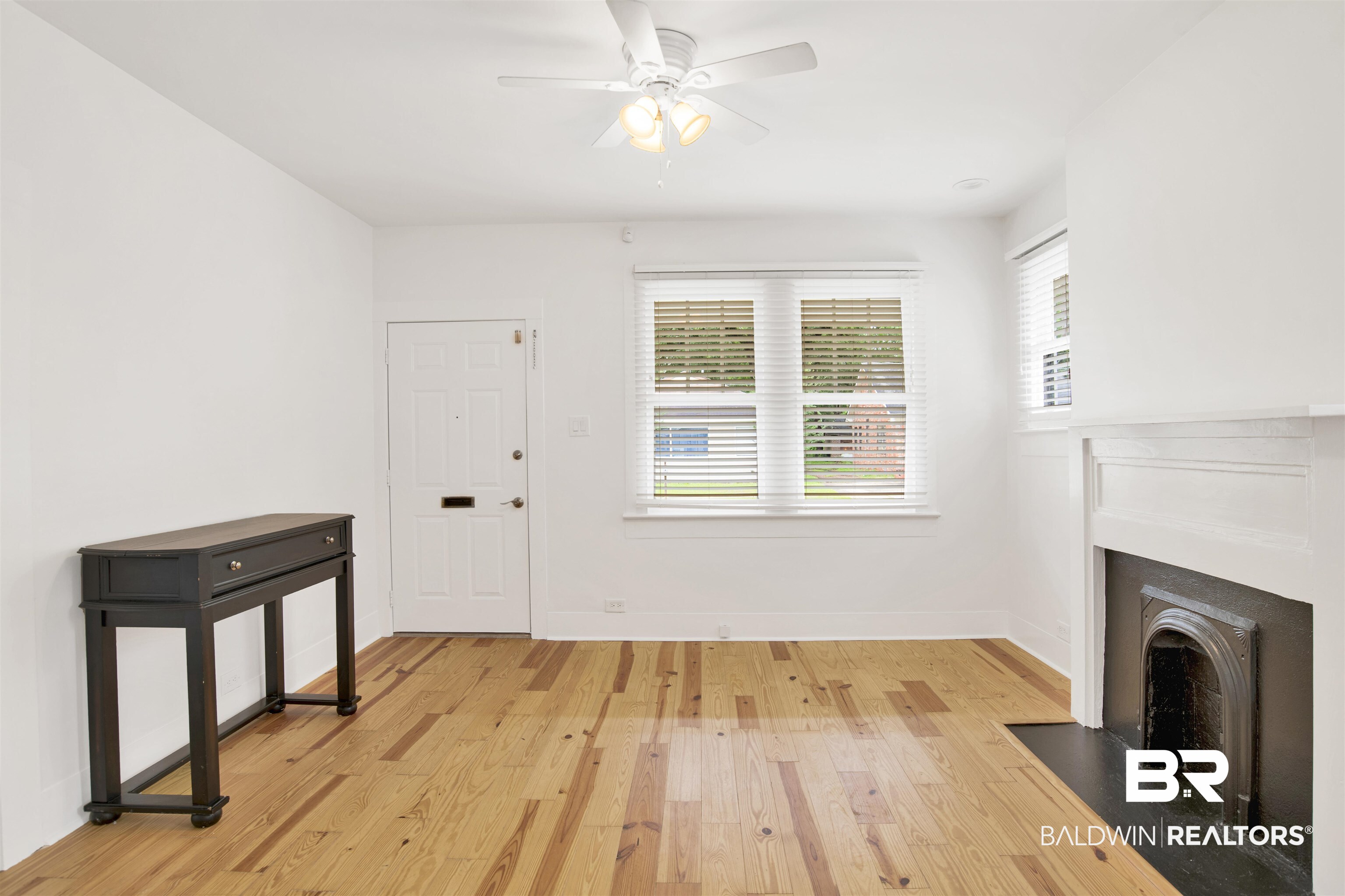 507 Holcombe Avenue Mobile, AL 36606 - Photo 19 of 28 Unfurnished living room featuring light wood-style floors, ceiling fan, a fireplace with flush hearth, and baseboards