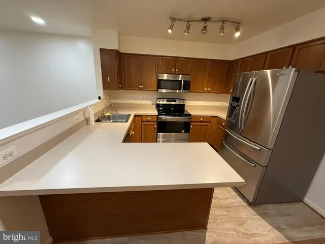 a kitchen with kitchen island a stove a sink and a refrigerator