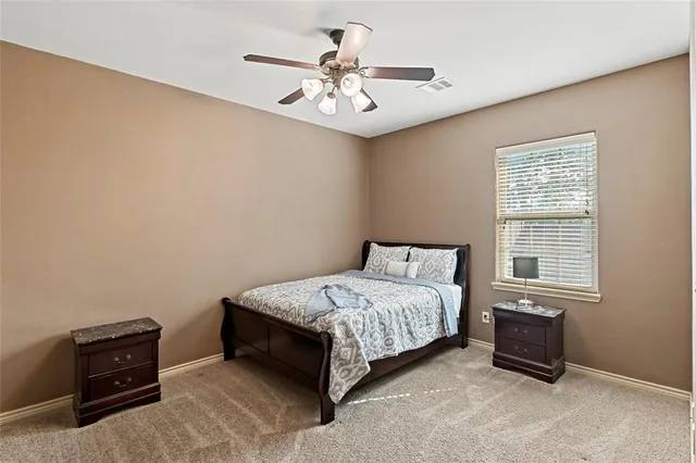 a bedroom with a bed and a ceiling fan