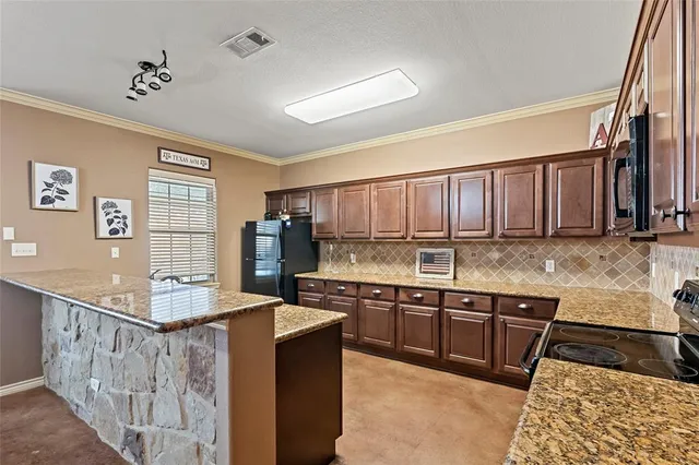 a kitchen with stainless steel appliances granite countertop a sink stove and refrigerator