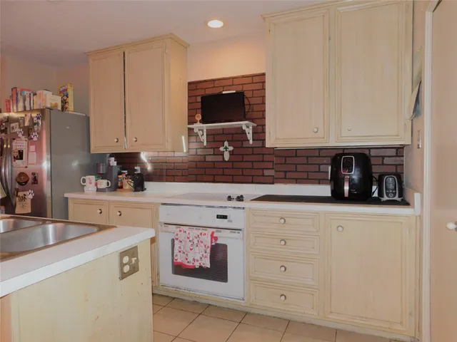 a kitchen with stainless steel appliances a stove a sink and white cabinets