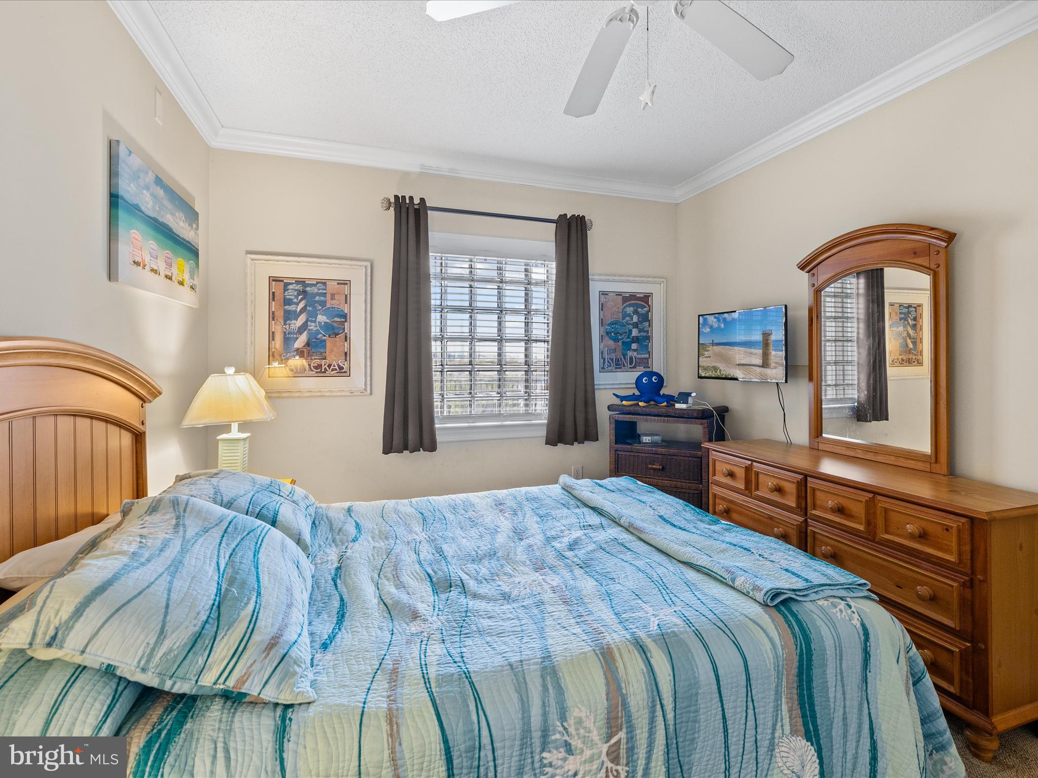 11900 Coastal Highway, Unit 102 Ocean City, MD 21842 - Photo 19 of 39 a bedroom with a bed and dresser with mirror