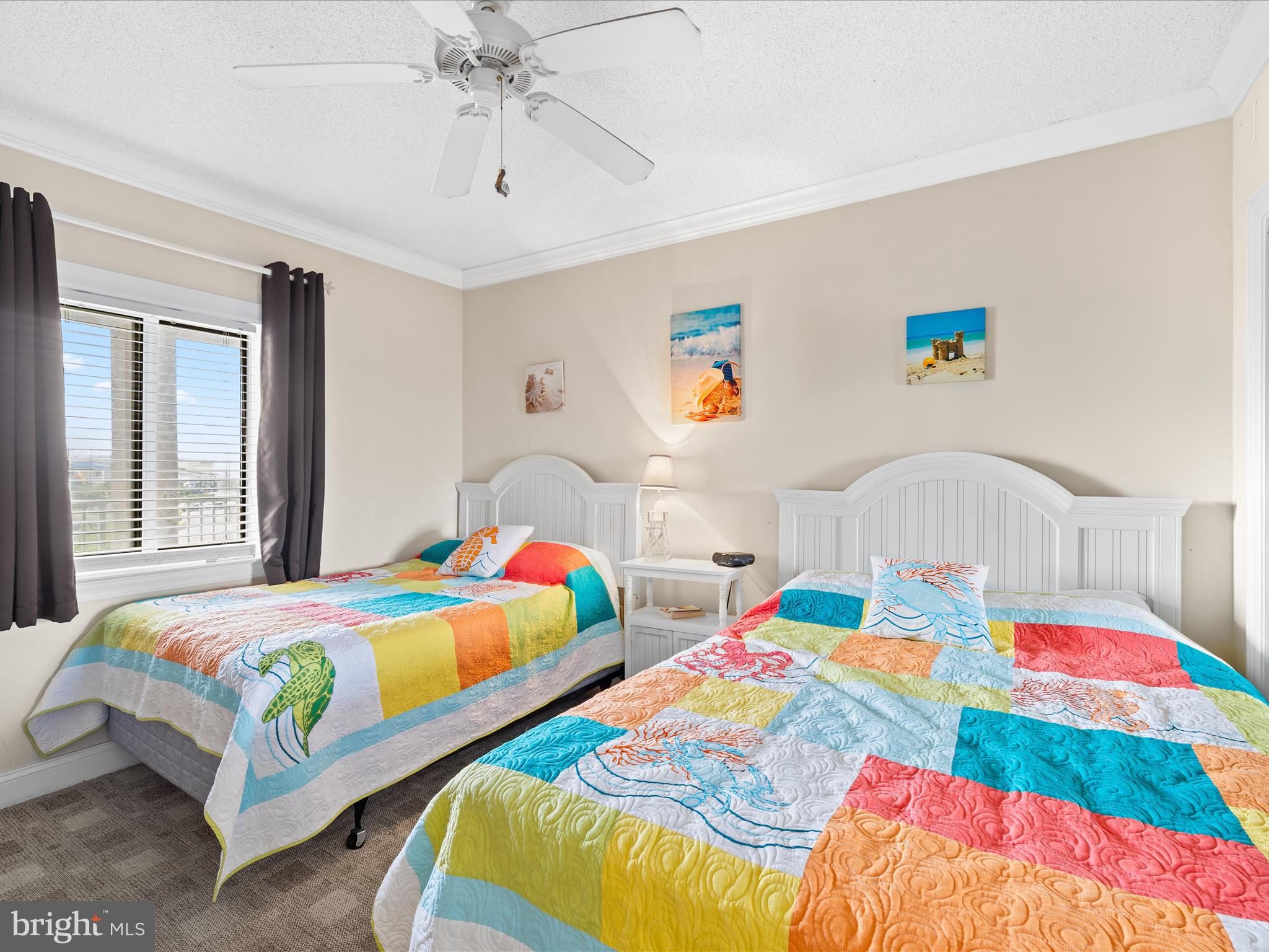 11900 Coastal Highway, Unit 102 Ocean City, MD 21842 - Photo 22 of 39 a bedroom with two beds and a chandelier