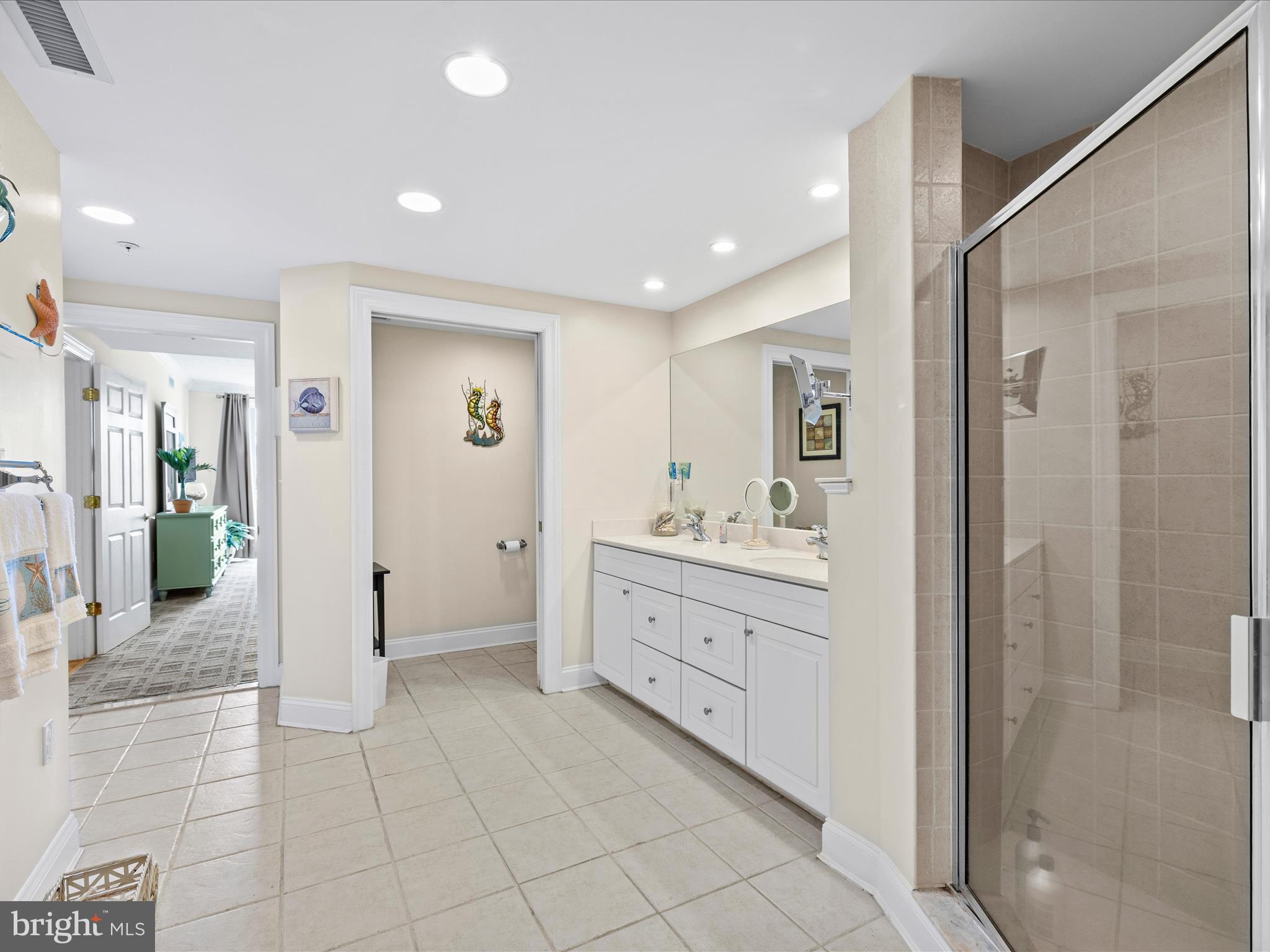 11900 Coastal Highway, Unit 102 Ocean City, MD 21842 - Photo 27 of 39 a spacious bathroom with a double vanity sink and a mirror