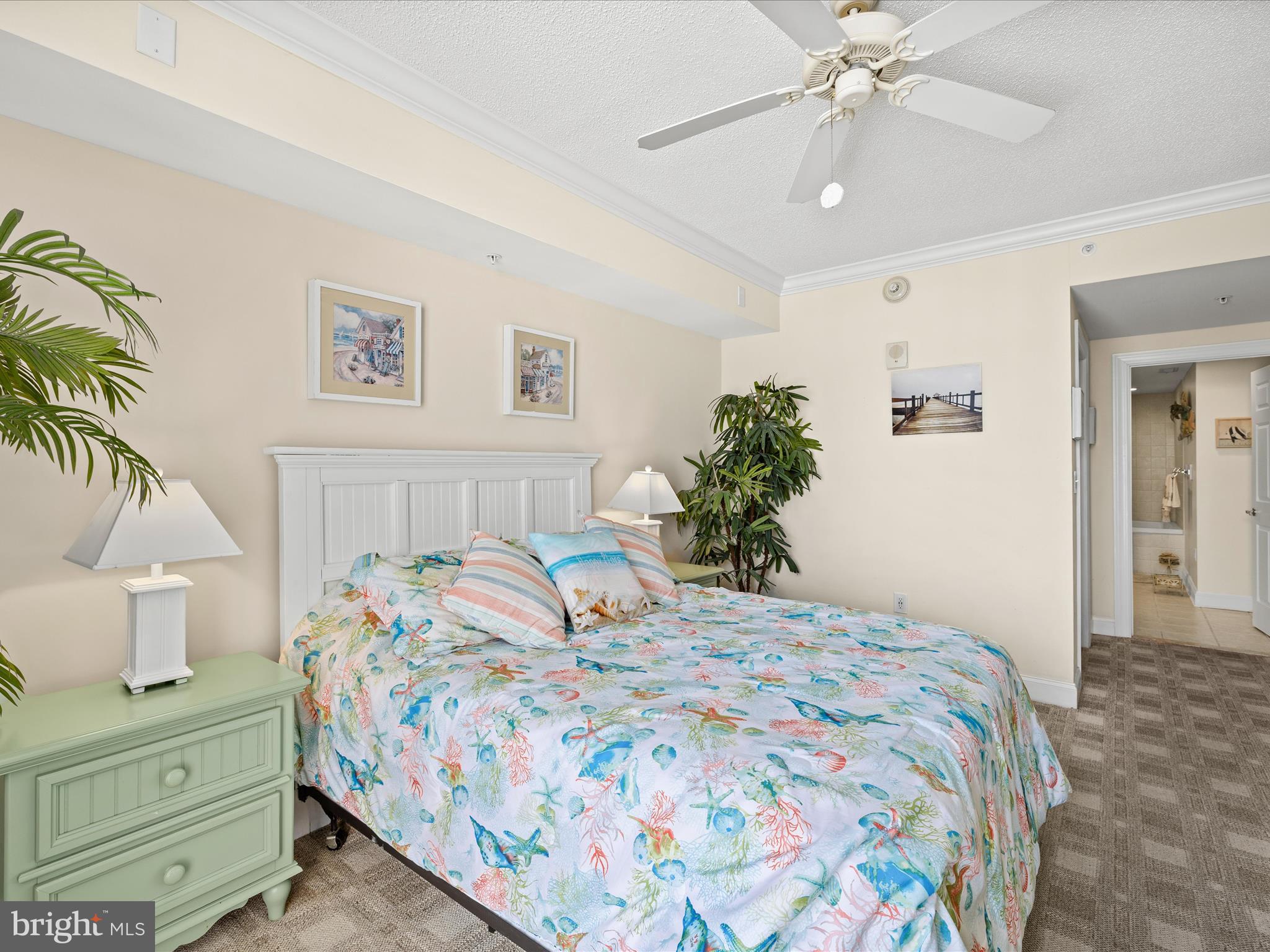 11900 Coastal Highway, Unit 102 Ocean City, MD 21842 - Photo 29 of 39 a bedroom with a bed and a chandelier
