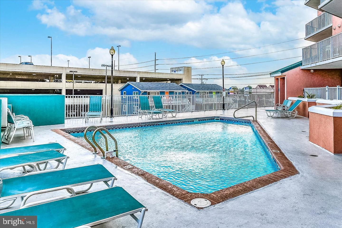 11900 Coastal Highway, Unit 102 Ocean City, MD 21842 - Photo 6 of 39 a view of a swimming pool with a lounge chairs