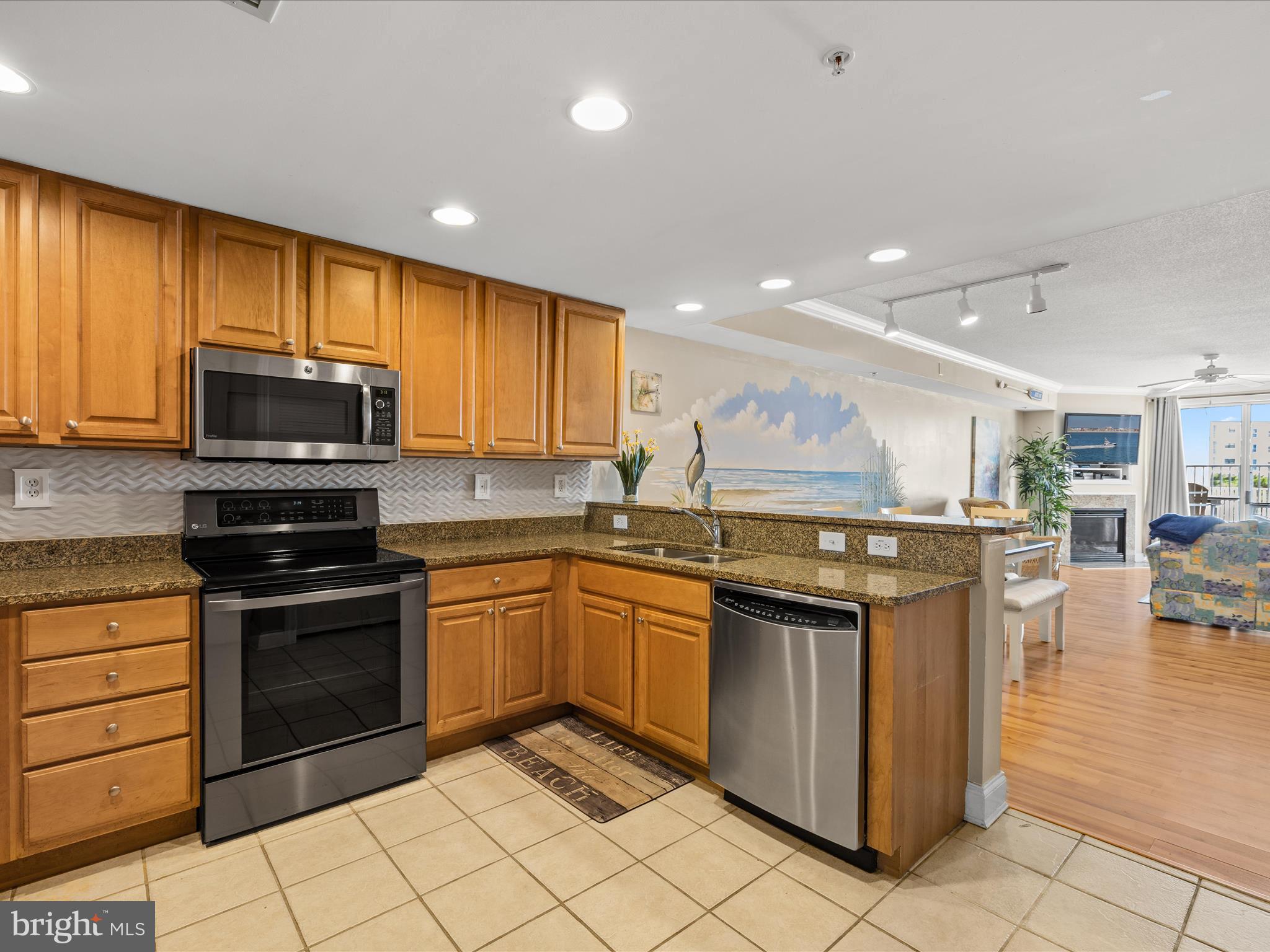 11900 Coastal Highway, Unit 102 Ocean City, MD 21842 - Photo 7 of 39 a kitchen with stainless steel appliances granite countertop a stove top oven a sink dishwasher and a refrigerator