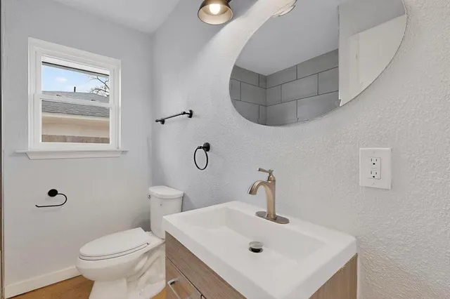 a bathroom with a sink toilet and mirror