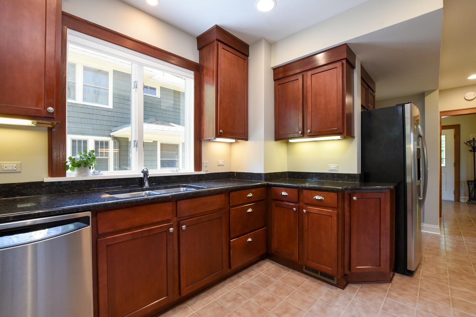 347 Herrick Road Riverside, IL 60546 - Photo 8 of 28 a kitchen with stainless steel appliances granite countertop wooden cabinets a sink and a large window