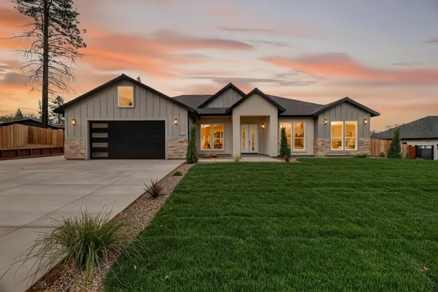 a front view of a house with a garden and yard