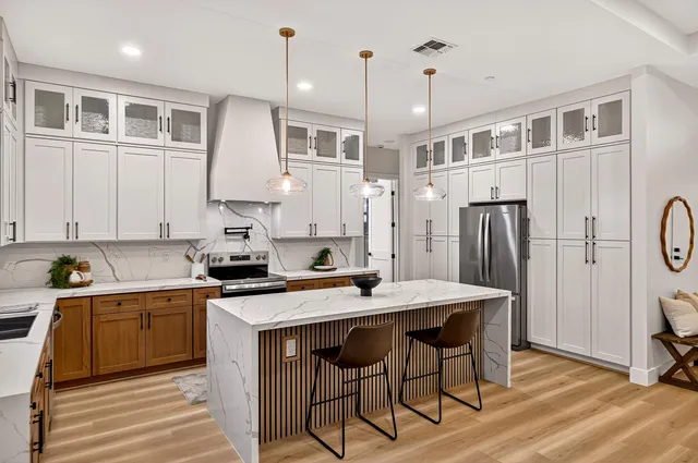a kitchen with stainless steel appliances granite countertop a sink a stove and a refrigerator