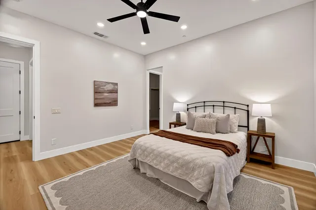 a bedroom with a bed and a lamp on the dresser