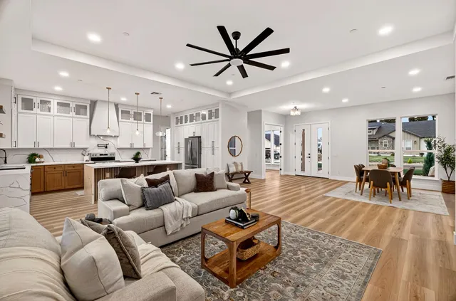 a living room with furniture a dining table and chairs with wooden floor
