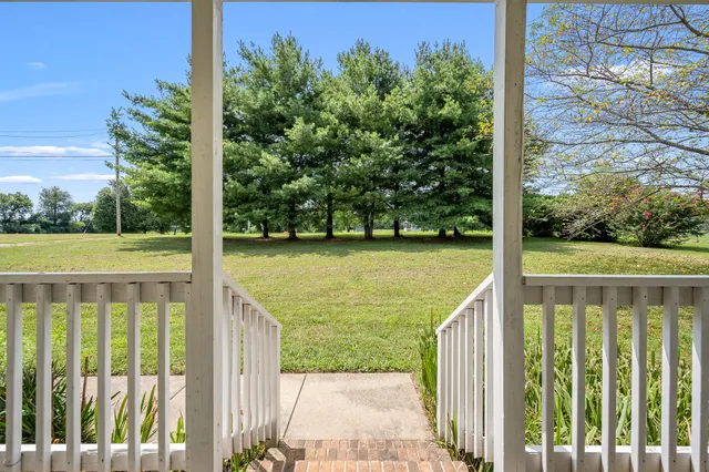 a view of an empty room and window and wooden floor