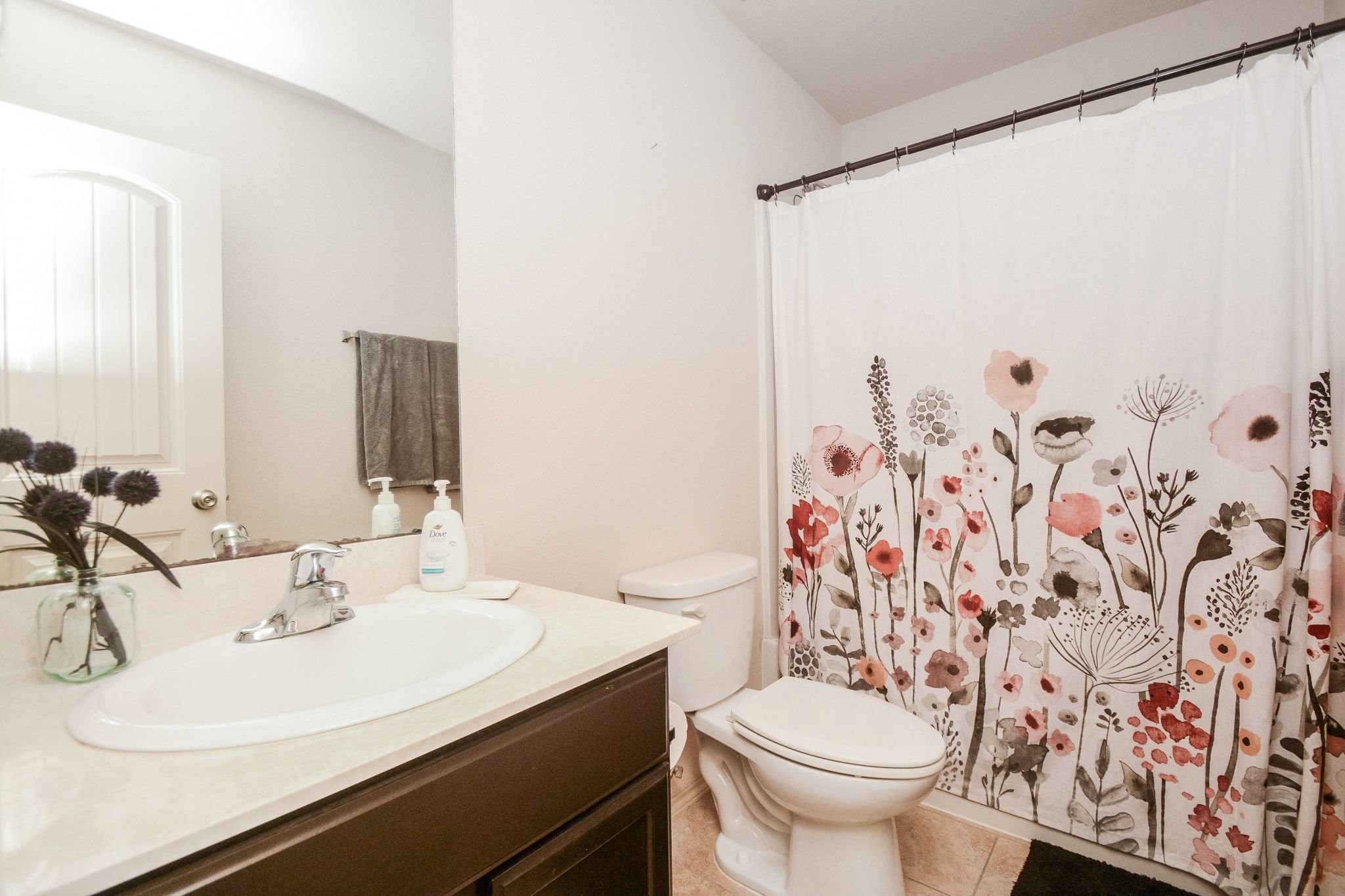 23318 Dukes Run Drive Spring, TX 77373 - Photo 21 of 41 This bathroom features a clean, modern design with a white sink and countertop, and dark cabinetry. The light walls and tile flooring add a bright and welcoming touch.