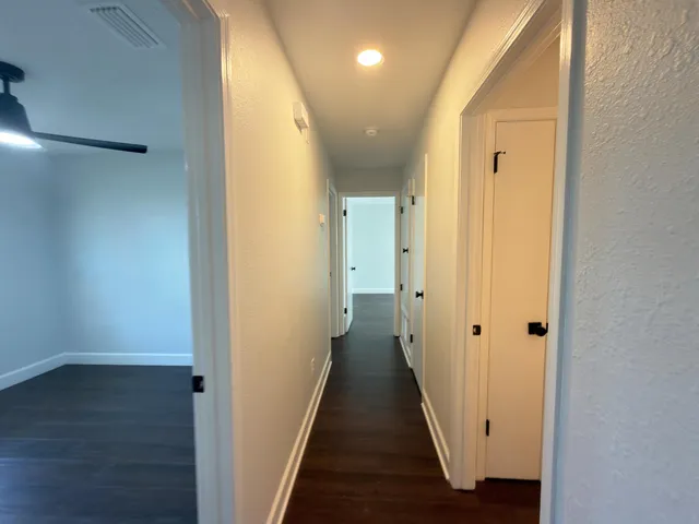 a view of a hallway with wooden floor