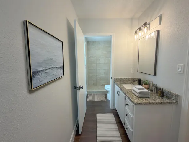a bathroom with a granite countertop sink and a mirror